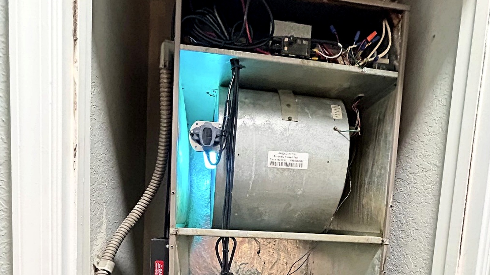 AQ AC & Electric technician servicing an open air handler