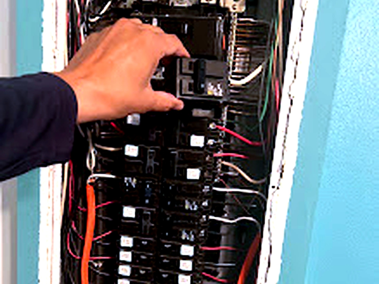 AQ AC & Electric electrician working in a breaker panel